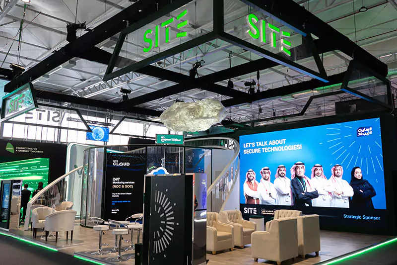 A modern exhibition booth with branded structures and lighting.